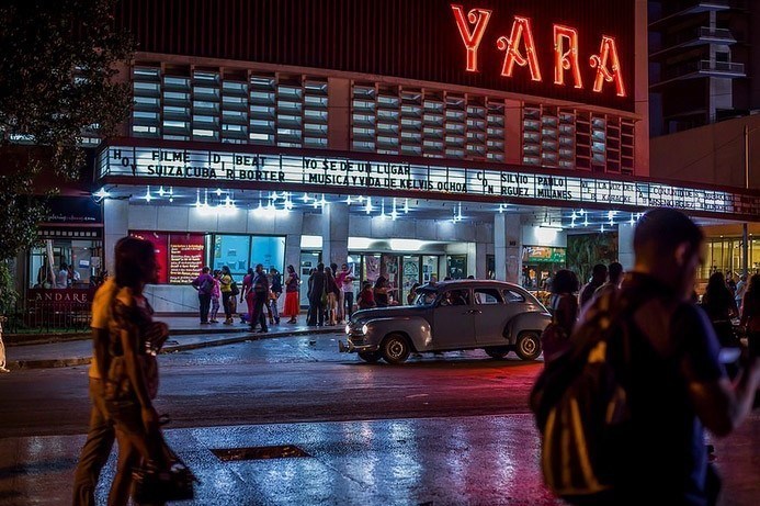 La-Rampa,Havana, in front of the Cinema Yara with old car and cuban girls